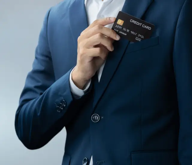 a man in a suit putting a credit card in his pocket