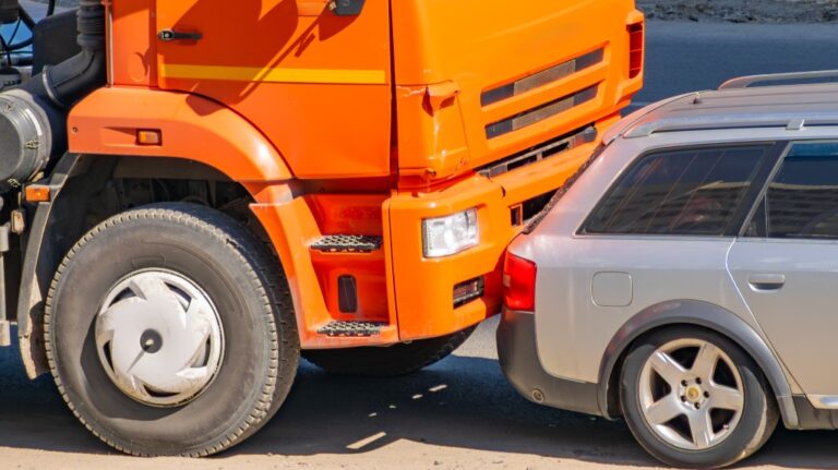 car accident between an orange truck and passenger car