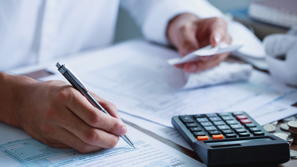 man looks through receipts makes calculations