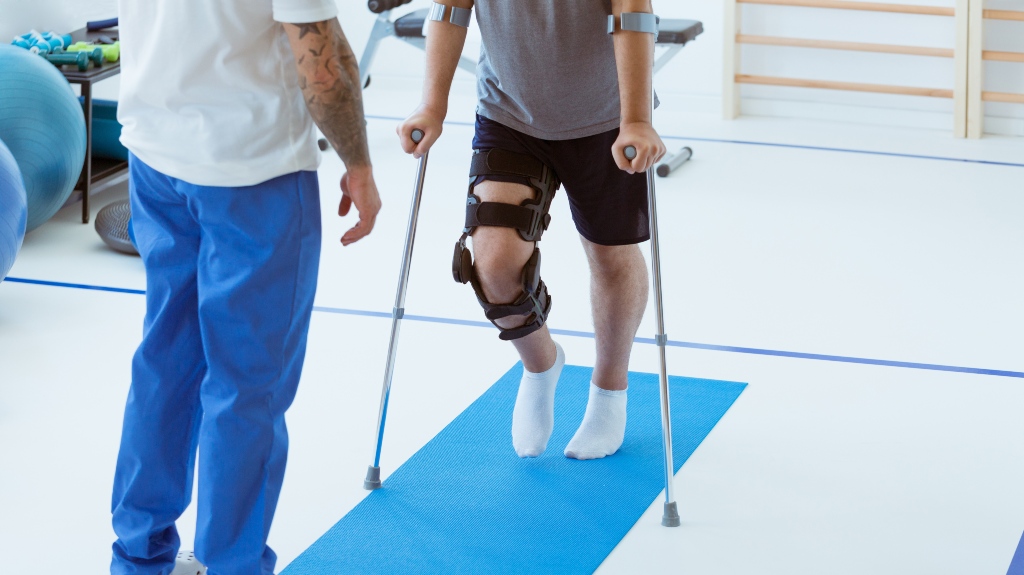 Man after car accident in an orthosis and on crutches