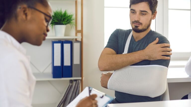 doctor at hospital prescribing treatment and talking to young patient wearing scarf bandage