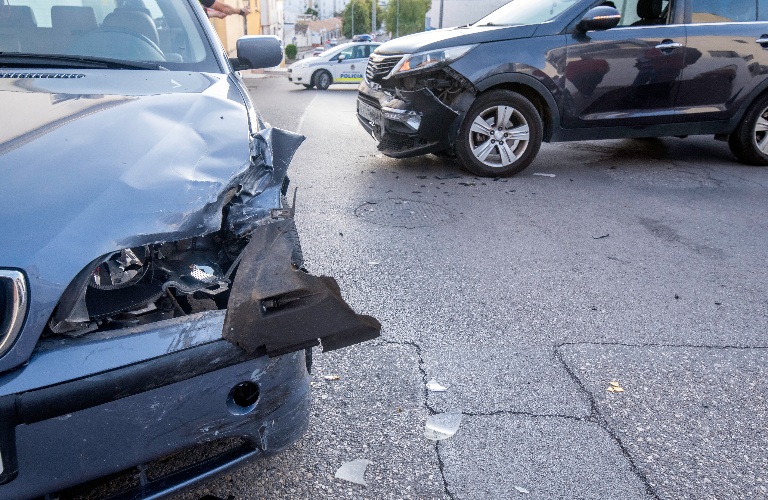 road with two cars that have had an accident with material damage to both cars