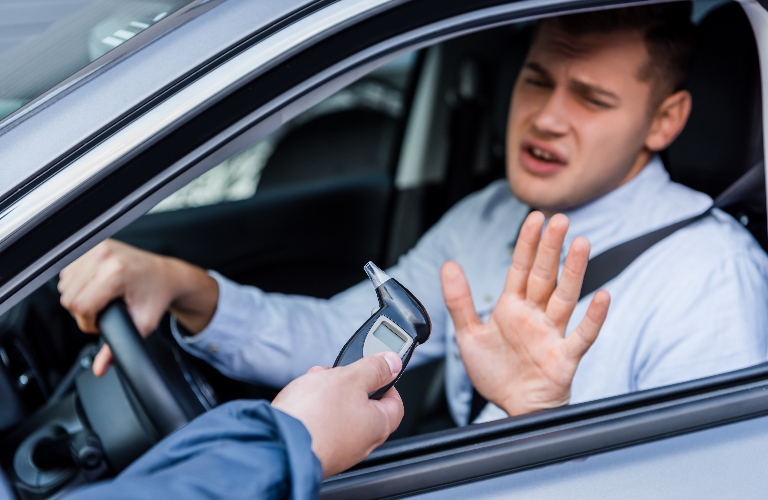 policeman giving breathalyzer to driver showing refuse gesture