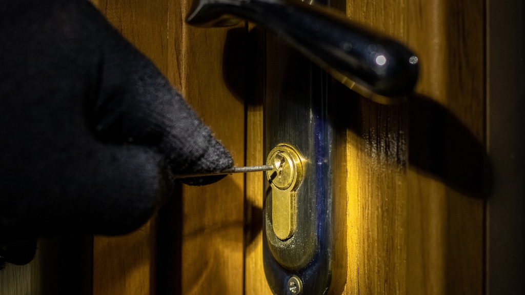 The thief tries to open the lock in the door with a special key