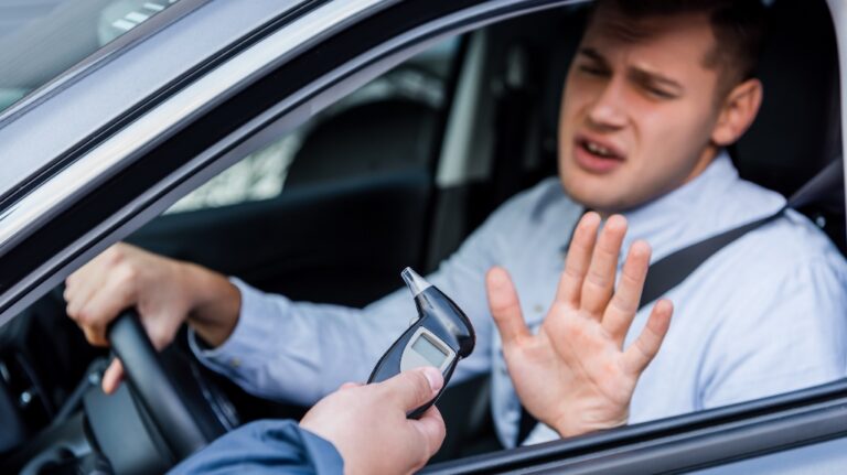policeman giving breathalyzer to driver showing refuse gesture