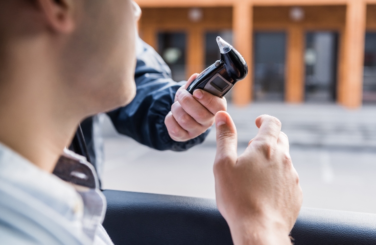 policeman giving breathalyzer to driver