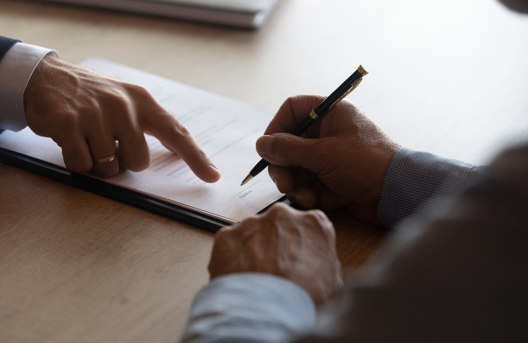Hands of lawyer pointing at paper for signing document