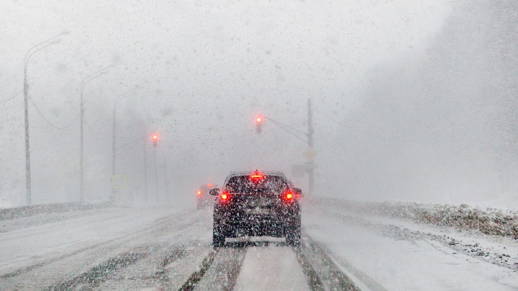 Cars driving on road in snowfall