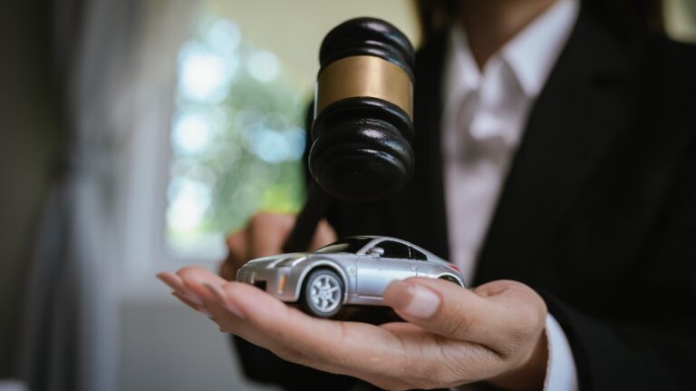 Lawyer is holding car model and judge's gavel