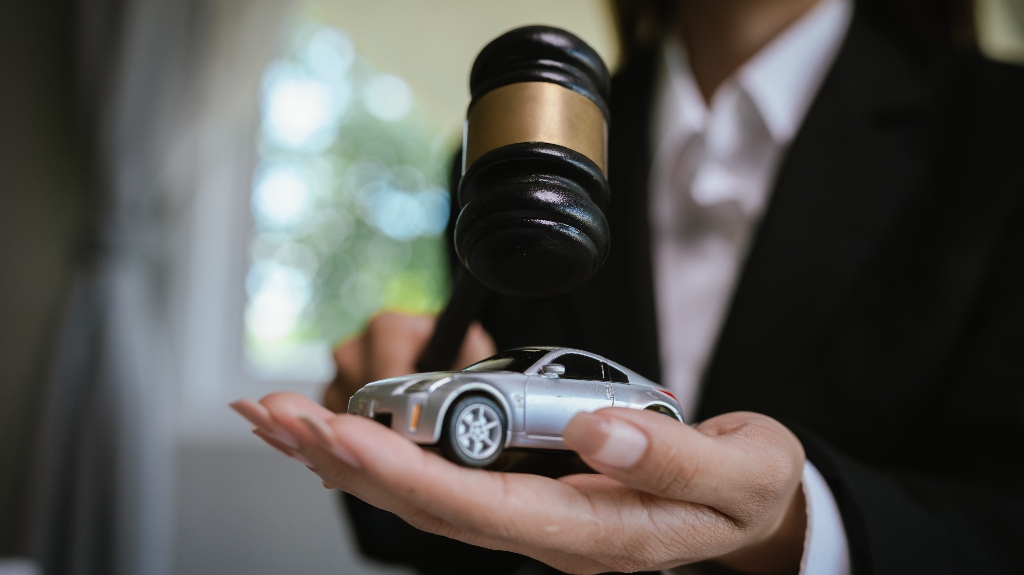 Lawyer is holding car model and judge's gavel