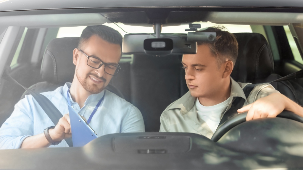 Young man with instructor passing driving license test outdoors