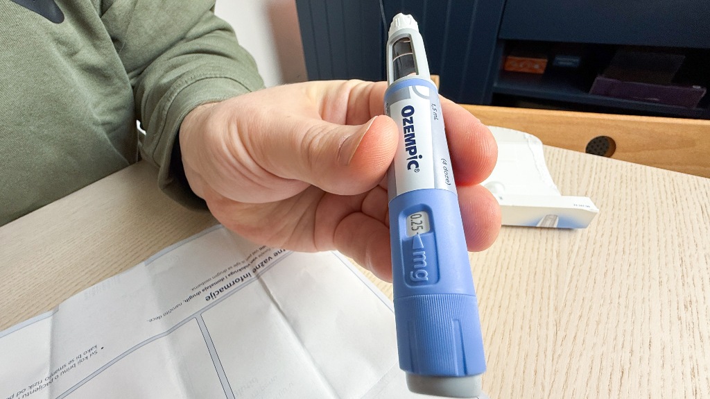 hand holding a blue Ozempic pen, symbolizing health empowerment and modern wellness